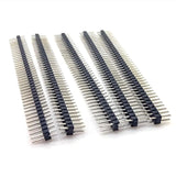 Four long strips of ShillehTek dual male header pins angled on white surface