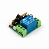 Close-up side view of relay module with visible blue relay and coil antenna