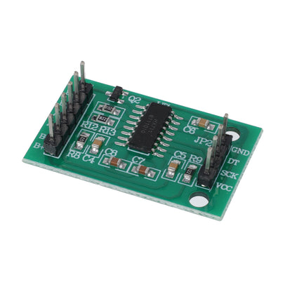 Tilted close-up of green HX711 amplifier module with circuit components for Arduino