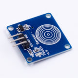 TTP223B capacitive touch switch sensor module with blue PCB and three pin headers angled view