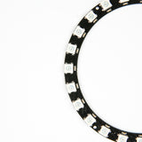 Close-up view of WS2812 24-bit RGB LED ring with black circuit board and white LEDs