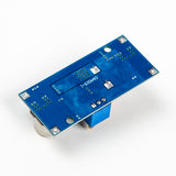 Back side view of XL4015 adjustable DC-DC step-down module showing blue PCB and solder points