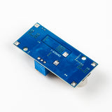 Back side view of XL4015 adjustable DC-DC step-down module showing blue PCB and solder points